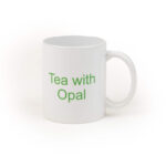 A close up of a while mug with green text "Tea with Opal".